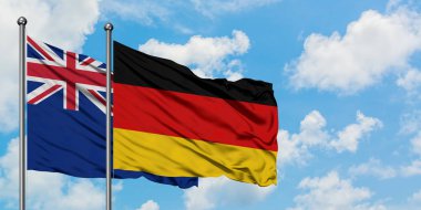 Yeni Zelanda ve Almanya bayrağı birlikte beyaz bulutlu mavi gökyüzüne karşı rüzgarsal sallayarak. Diplomasi kavramı, uluslararası ilişkiler.