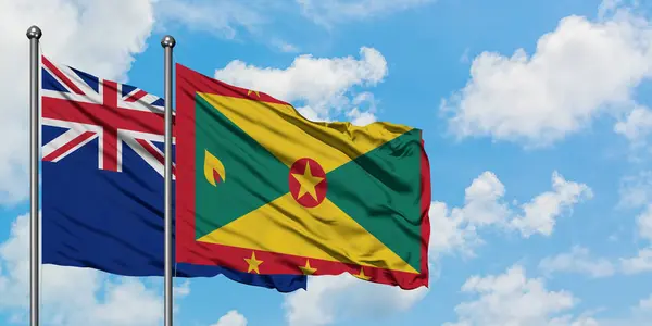 Bandera de Nueva Zelanda y Granada ondeando en el viento contra el cielo azul nublado blanco juntos. Concepto diplomático, relaciones internacionales . — Foto de Stock