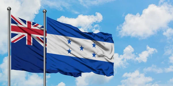 Nieuw-Zeeland en Honduras vlag zwaaien in de wind tegen witte bewolkte blauwe hemel samen. Diplomatie concept, internationale betrekkingen. — Stockfoto