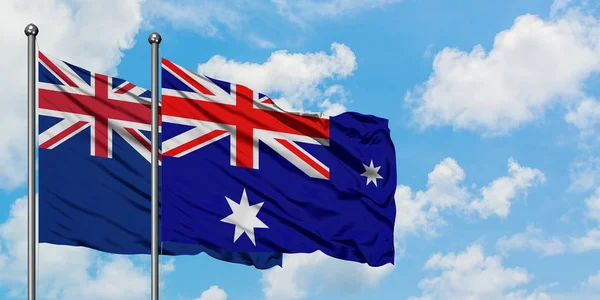 Új-Zéland és a Heard-sziget és McDonald-szigetek zászló integetett a szél ellen, fehér felhős kék ég együtt. Diplomáciai koncepció, nemzetközi kapcsolatok. — Stock Fotó