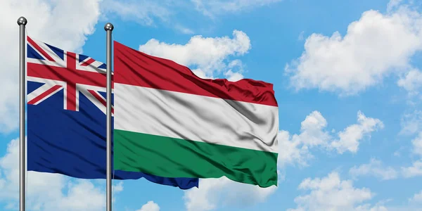 Új-Zéland és Magyarország zászló integetett a szél a fehér felhős kék ég együtt. Diplomáciai koncepció, nemzetközi kapcsolatok. — Stock Fotó