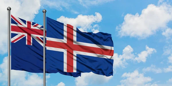Bandera de Nueva Zelanda e Islandia ondeando en el viento contra el cielo azul nublado blanco juntos. Concepto diplomático, relaciones internacionales . — Foto de Stock