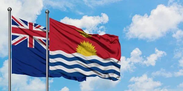 Bandera de Nueva Zelanda y Kiribati ondeando en el viento contra el cielo azul nublado blanco juntos. Concepto diplomático, relaciones internacionales . — Foto de Stock