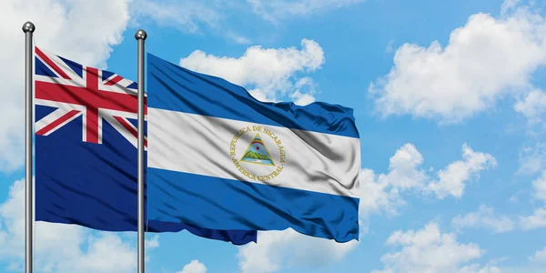 Neuseeland und Nicaragua schwenken gemeinsam die Flagge im Wind vor dem wolkenverhangenen blauen Himmel. Diplomatie-Konzept, internationale Beziehungen. — Stockfoto