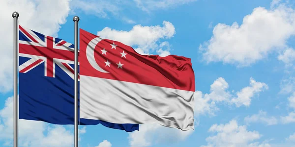 Bandeira da Nova Zelândia e Singapura agitando no vento contra o céu azul nublado branco juntos. Conceito de diplomacia, relações internacionais . — Fotografia de Stock