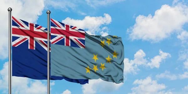 Bandera de Nueva Zelanda y Tuvalu ondeando en el viento contra el cielo azul nublado blanco juntos. Concepto diplomático, relaciones internacionales . — Foto de Stock