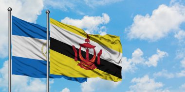 Nikaragua ve Brunei bayrağı birlikte beyaz bulutlu mavi gökyüzüne karşı rüzgarda sallayarak. Diplomasi kavramı, uluslararası ilişkiler.