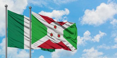 Nijerya ve Burundi bayrağı birlikte beyaz bulutlu mavi gökyüzüne karşı rüzgarda sallayarak. Diplomasi kavramı, uluslararası ilişkiler.