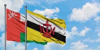 Umman ve Brunei bayrağı birlikte beyaz bulutlu mavi gökyüzüne karşı rüzgarda sallayarak. Diplomasi kavramı, uluslararası ilişkiler.