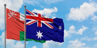 Umman ve Heard Adası ve Mcdonald Adaları bayrağı birlikte beyaz bulutlu mavi gökyüzüne karşı rüzgarda sallayarak. Diplomasi kavramı, uluslararası ilişkiler.