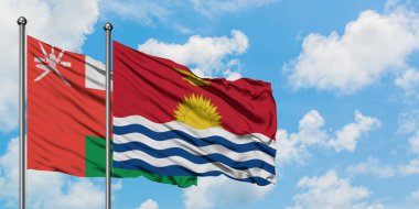 Umman ve Kiribati bayrağı birlikte beyaz bulutlu mavi gökyüzüne karşı rüzgarda sallayarak. Diplomasi kavramı, uluslararası ilişkiler.