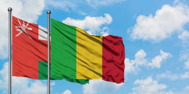 Umman ve Mali bayrağı birlikte beyaz bulutlu mavi gökyüzüne karşı rüzgarda sallayarak. Diplomasi kavramı, uluslararası ilişkiler.