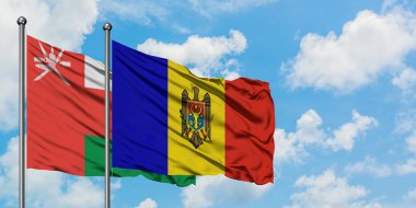Umman ve Moldova bayrağı birlikte beyaz bulutlu mavi gökyüzüne karşı rüzgarda sallayarak. Diplomasi kavramı, uluslararası ilişkiler.