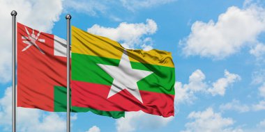 Umman ve Myanmar bayrağı birlikte beyaz bulutlu mavi gökyüzüne karşı rüzgarda sallayarak. Diplomasi kavramı, uluslararası ilişkiler.
