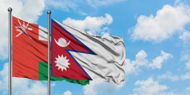 Umman ve Nepal bayrağı birlikte beyaz bulutlu mavi gökyüzüne karşı rüzgarda sallayarak. Diplomasi kavramı, uluslararası ilişkiler.