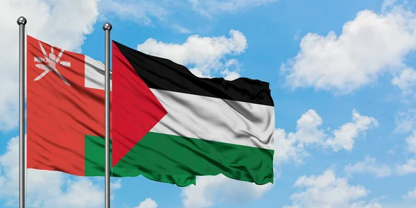 Omán és Palesztina zászló integetett a szél ellen fehér felhős kék ég együtt. Diplomáciai koncepció, nemzetközi kapcsolatok. — Stock Fotó