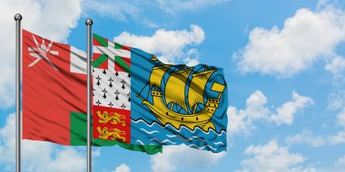 Umman ve Saint Pierre ve Miquelon bayrağı birlikte beyaz bulutlu mavi gökyüzüne karşı rüzgarda sallayarak. Diplomasi kavramı, uluslararası ilişkiler.