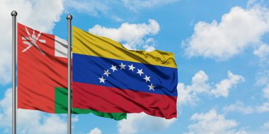 Umman ve Venezuela bayrağı birlikte beyaz bulutlu mavi gökyüzüne karşı rüzgarda sallayarak. Diplomasi kavramı, uluslararası ilişkiler.