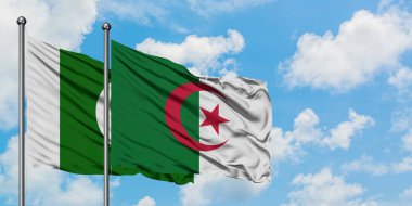 Pakistan ve Cezayir bayrağı birlikte beyaz bulutlu mavi gökyüzüne karşı rüzgarda sallayarak. Diplomasi kavramı, uluslararası ilişkiler.