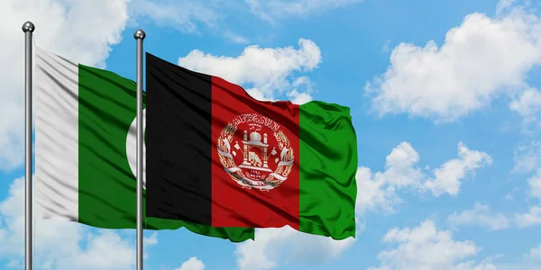 Bandera de Pakistán y Afganistán ondeando en el viento contra el cielo azul nublado blanco juntos. Concepto diplomático, relaciones internacionales . — Foto de Stock