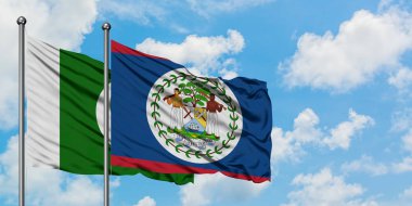 Pakistan ve Belize bayrağı birlikte beyaz bulutlu mavi gökyüzüne karşı rüzgarda sallayarak. Diplomasi kavramı, uluslararası ilişkiler.