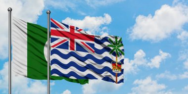 Pakistan ve İngiliz Hint Okyanusu Toprakları bayrağı birlikte beyaz bulutlu mavi gökyüzüne karşı rüzgarda sallayarak. Diplomasi kavramı, uluslararası ilişkiler.