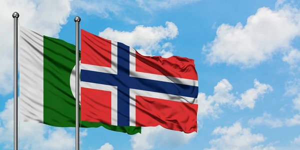 Bandera de Pakistán y Bouvet Islands ondeando en el viento contra el cielo azul nublado blanco juntos. Concepto diplomático, relaciones internacionales . — Foto de Stock