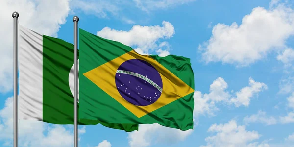 Drapeau du Pakistan et du Brésil agitant dans le vent contre ciel bleu nuageux blanc ensemble. Concept de diplomatie, relations internationales . — Photo