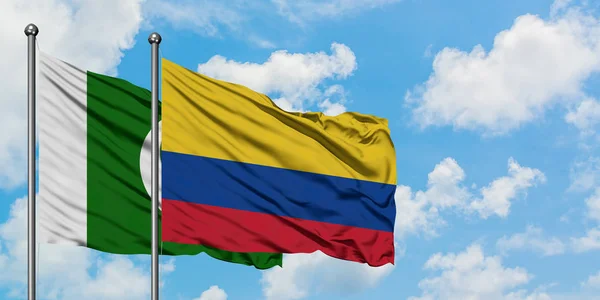 Pakistan e Colombia sventolano bandiera nel vento contro bianco cielo blu nuvoloso insieme. Concetto di diplomazia, relazioni internazionali . — Foto Stock