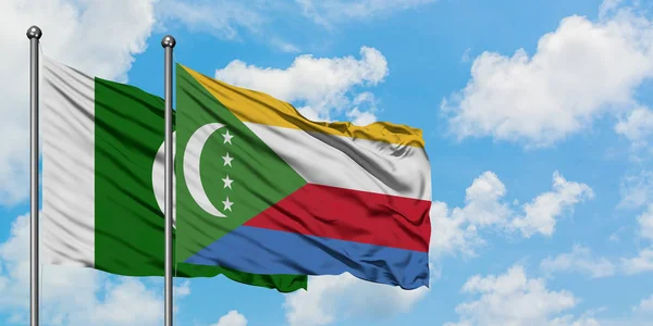 Bandera de Pakistán y Comoras ondeando en el viento contra el cielo azul nublado blanco juntos. Concepto diplomático, relaciones internacionales . — Foto de Stock