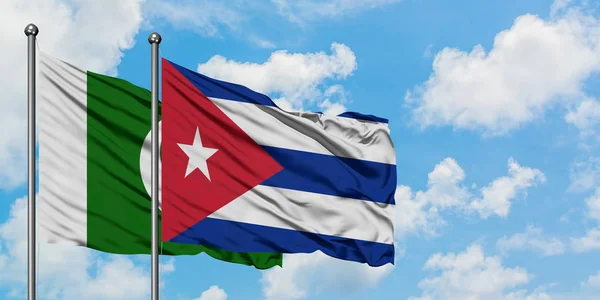 Drapeau du Pakistan et de Cuba agitant dans le vent contre ciel bleu nuageux blanc ensemble. Concept de diplomatie, relations internationales . — Photo