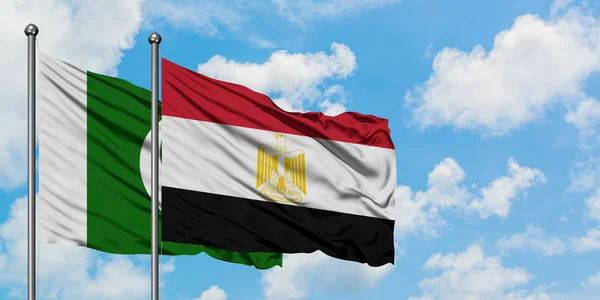 Bandera de Pakistán y Egipto ondeando en el viento contra el cielo azul nublado blanco juntos. Concepto diplomático, relaciones internacionales . — Foto de Stock