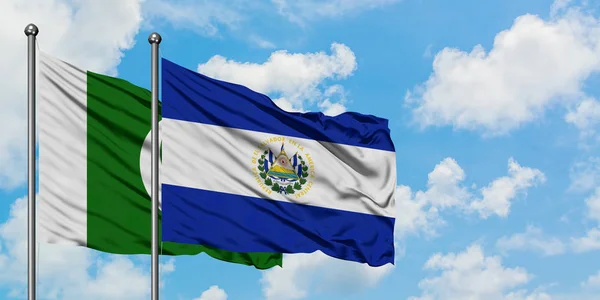 Pakistan ve El Salvador bayrağı birlikte beyaz bulutlu mavi gökyüzüne karşı rüzgarda sallayarak. Diplomasi kavramı, uluslararası ilişkiler. — Stok fotoğraf