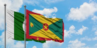 Pakistan ve Grenada bayrağı birlikte beyaz bulutlu mavi gökyüzüne karşı rüzgarda sallayarak. Diplomasi kavramı, uluslararası ilişkiler.