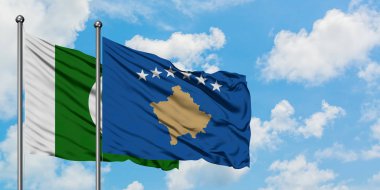 Pakistan ve Kosova bayrağı birlikte beyaz bulutlu mavi gökyüzüne karşı rüzgarda sallayarak. Diplomasi kavramı, uluslararası ilişkiler.