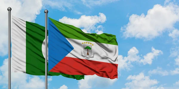 Bandera de Pakistán y Guinea Ecuatorial ondeando en el viento contra el cielo azul nublado blanco juntos. Concepto diplomático, relaciones internacionales . — Foto de Stock