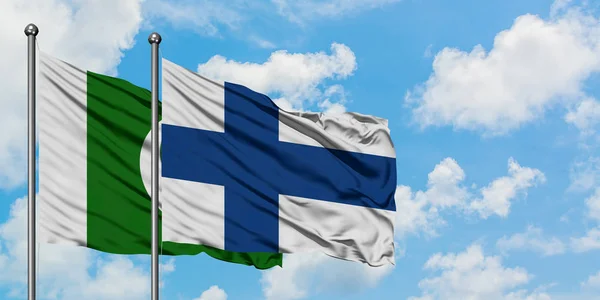 Pakistan e Finlandia sventolano bandiera nel vento contro bianco cielo blu nuvoloso insieme. Concetto di diplomazia, relazioni internazionali . — Foto Stock