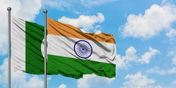 Bandera de Pakistán e India ondeando en el viento contra el cielo azul nublado blanco juntos. Concepto diplomático, relaciones internacionales . —  Fotos de Stock