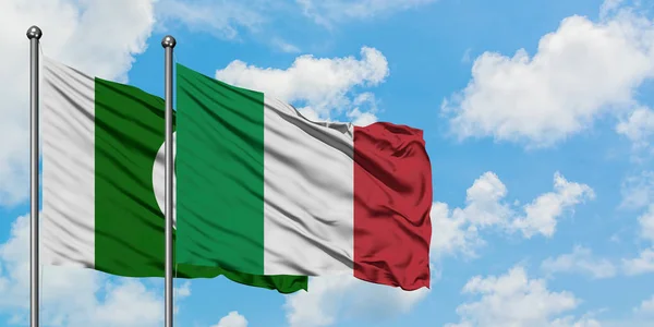 Pakistan och Italien sjunker vifta i vinden mot vit grumlig blå himmel tillsammans. Diplomatisk koncept, internationella relationer. — Stockfoto