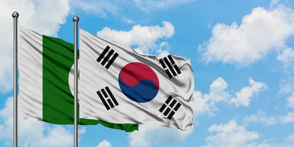 Pakistan i Korea Południowa flaga machając w wiatr przed białym zachmurzone błękitne niebo razem. Koncepcja dyplomacji, stosunki międzynarodowe. — Zdjęcie stockowe