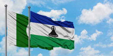 Pakistan ve Lesotho bayrağı birlikte beyaz bulutlu mavi gökyüzüne karşı rüzgarda sallayarak. Diplomasi kavramı, uluslararası ilişkiler.