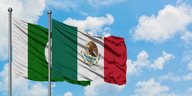 Pakistan ve Meksika bayrağı birlikte beyaz bulutlu mavi gökyüzüne karşı rüzgarda sallayarak. Diplomasi kavramı, uluslararası ilişkiler.