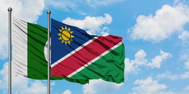 Pakistan ve Namibya bayrağı birlikte beyaz bulutlu mavi gökyüzüne karşı rüzgarda sallayarak. Diplomasi kavramı, uluslararası ilişkiler.