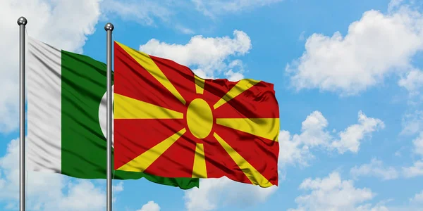 Paquistão e Macedônia acenando com o vento contra o céu azul nublado branco juntos. Conceito de diplomacia, relações internacionais . — Fotografia de Stock