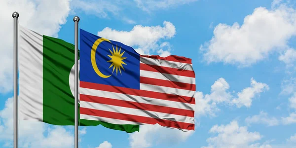 巴基斯坦和马来西亚国旗在风中飘扬，白云蓝天相聚。外交概念、国际关系. — 图库照片