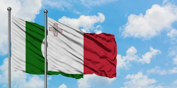 Bandera de Pakistán y Malta ondeando en el viento contra el cielo azul nublado blanco juntos. Concepto diplomático, relaciones internacionales . — Foto de Stock