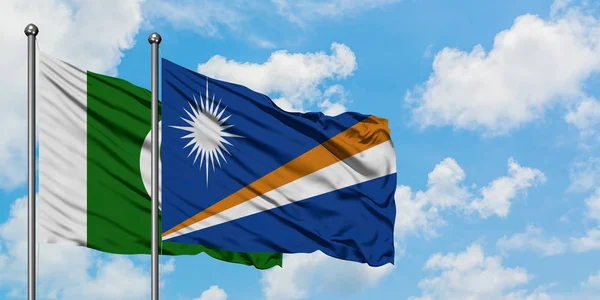 Η σημαία του Πακιστάν και των Νήσων Μάρσαλ κουνώντας τον άνεμο ενάντια στον λευκό συννεφιασμένο γαλάζιο ουρανό μαζί. Φιλοσοφία της διπλωματίας, διεθνείς σχέσεις. — Φωτογραφία Αρχείου