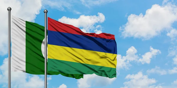 Paquistão e Mauritius bandeira acenando no vento contra o céu azul nublado branco juntos. Conceito de diplomacia, relações internacionais . — Fotografia de Stock