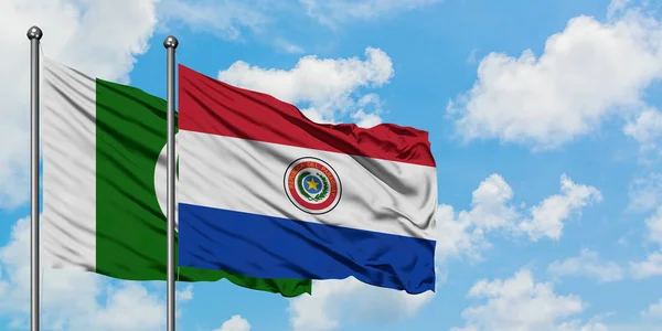 Bandera de Pakistán y Paraguay ondeando en el viento contra el cielo azul nublado blanco juntos. Concepto diplomático, relaciones internacionales . — Foto de Stock