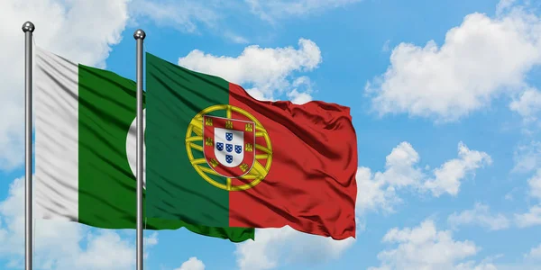 Bandera de Pakistán y Portugal ondeando en el viento contra el cielo azul nublado blanco juntos. Concepto diplomático, relaciones internacionales . — Foto de Stock